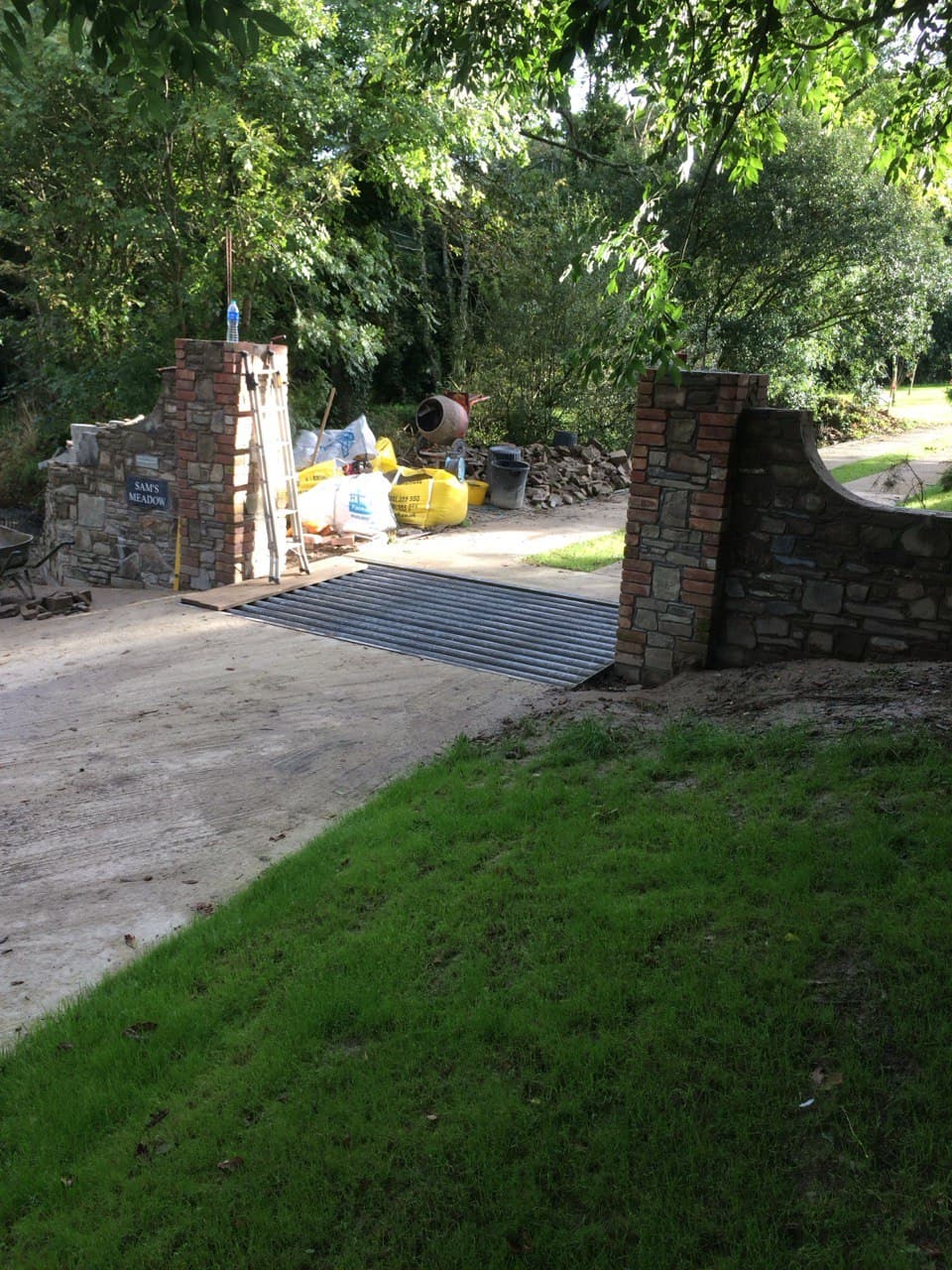 Completed entrance pillars with reclaimed stone and brick walls and cattle grid at Sam's Meadow property in North Cornwall