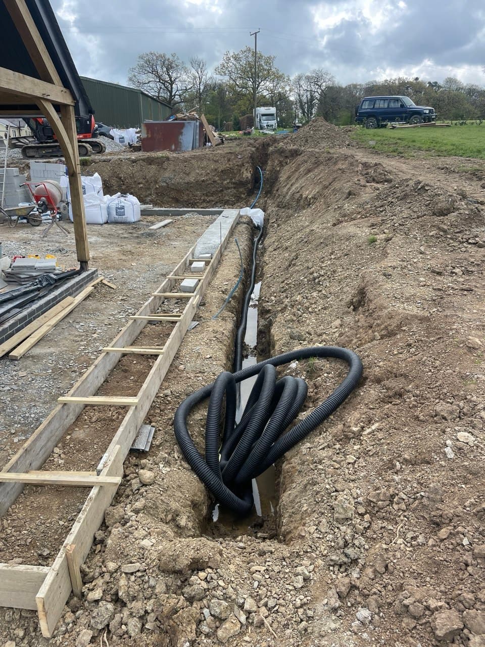 Drainage and service trench with corrugated ducting alongside new build property at Thornbury Devon