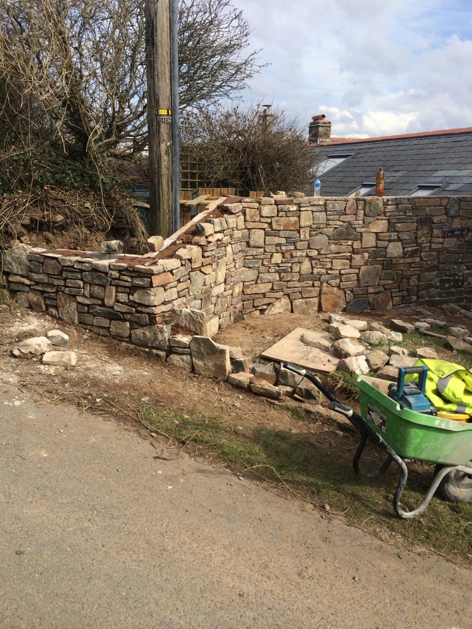 Traditional natural stone boundary wall under construction in a North Cornwall village by Spiby Build